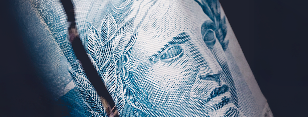 Imagem de uma cédula de real representando o impacto da reforma tributária na gestão fiscal das escolas particulares no Brasil.